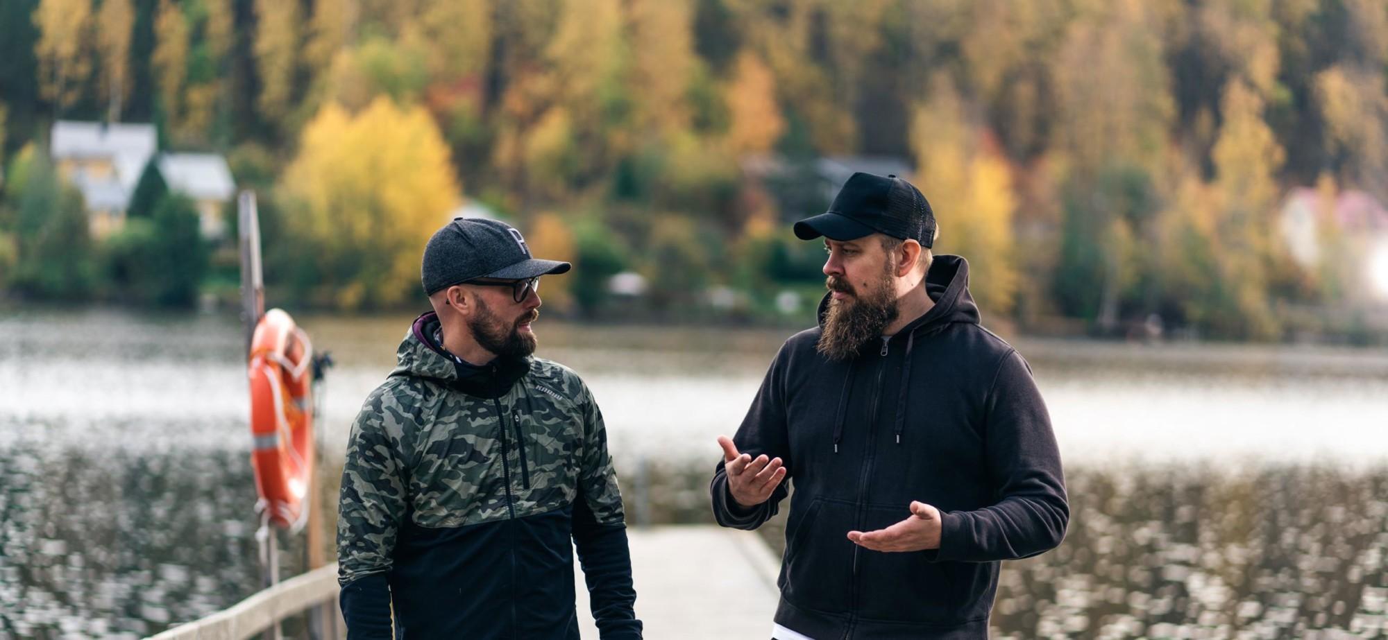 Two men are standing and talking on a pier.